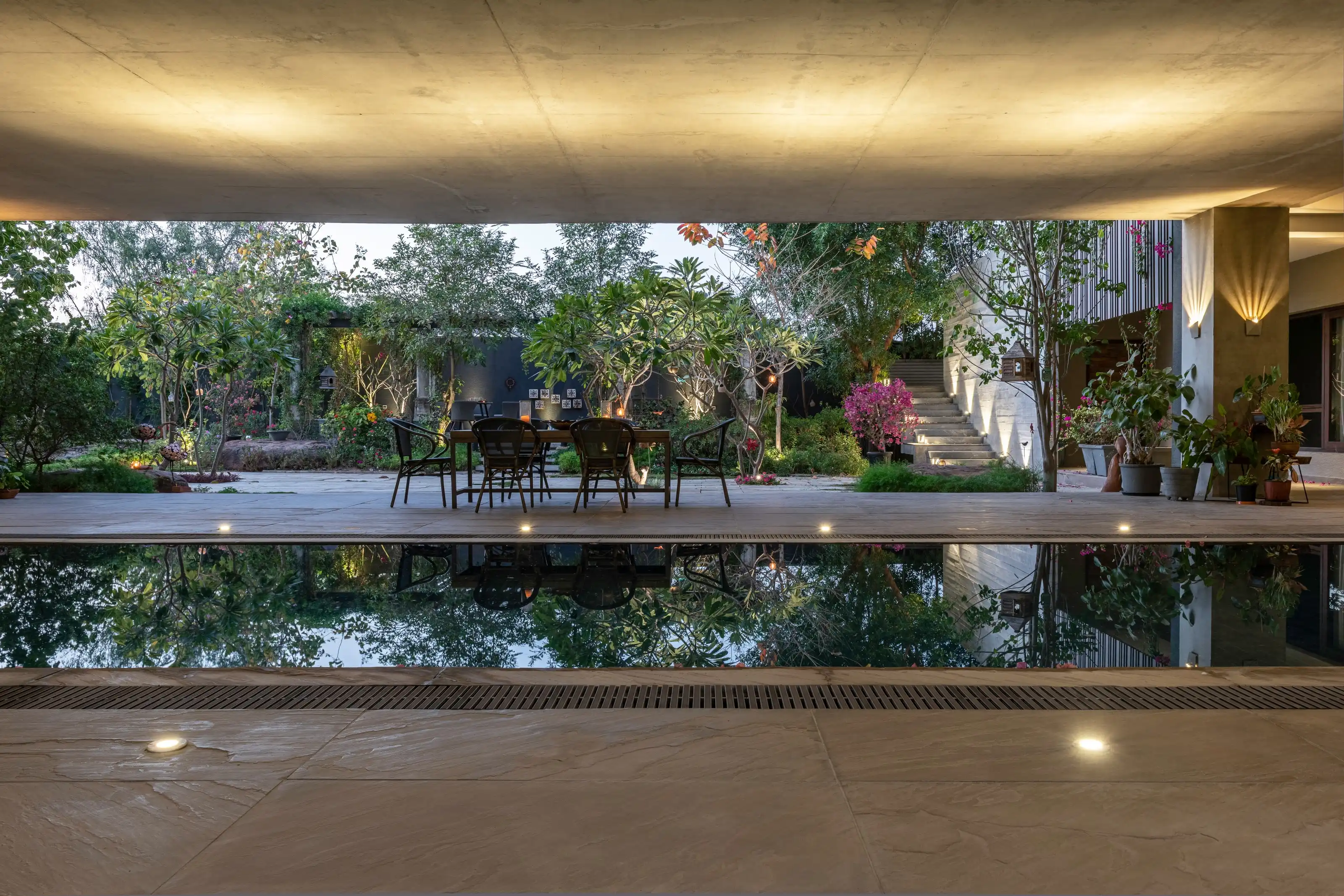 Twilight courtyard with a marble stair, a reflecting pool and a table set for two