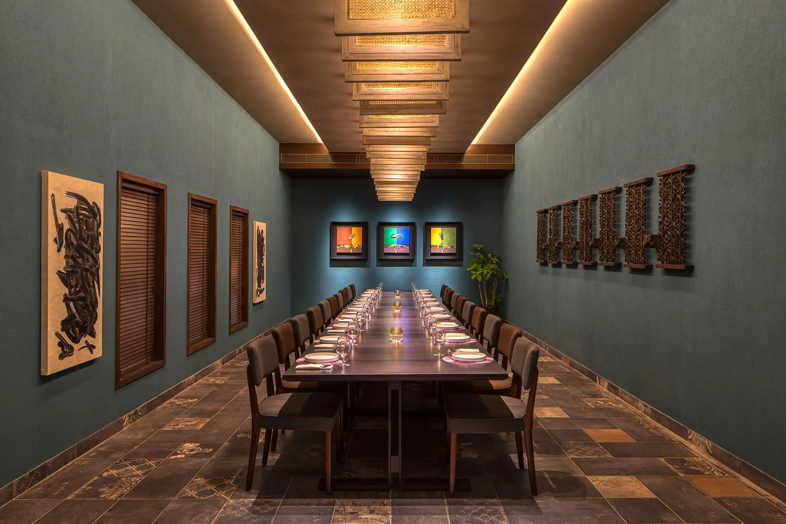 Private dining room with a single long table beneath a brass ceiling lattice