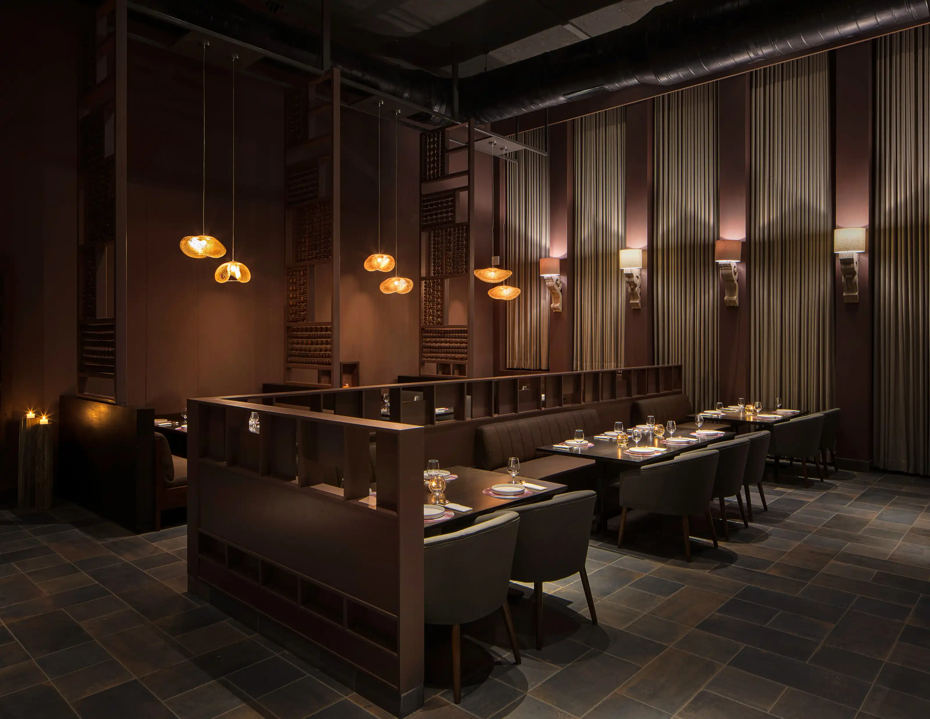 Dining booths beneath a wall of small framed antique architectural etchings